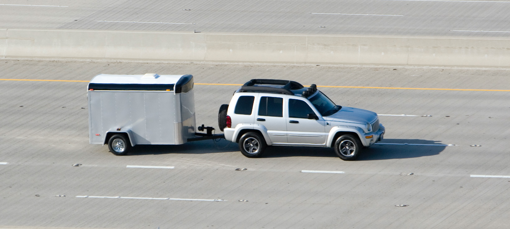 Aerial shot of a Triple-T Cargo trailer pulled by a suv on the highway